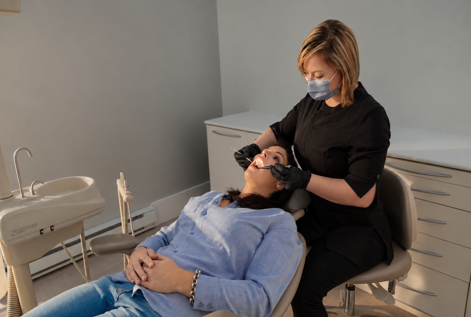 Dental professional examining a patient with the illuminated Halo Digital Mirror